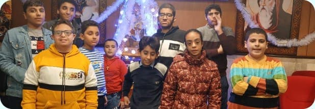 A group of smiling children and teenagers supported by the program