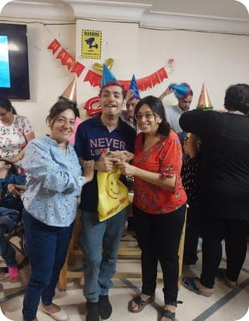 Two women and a happy boy at a birthday party for children with developmental disabilities in Egypt